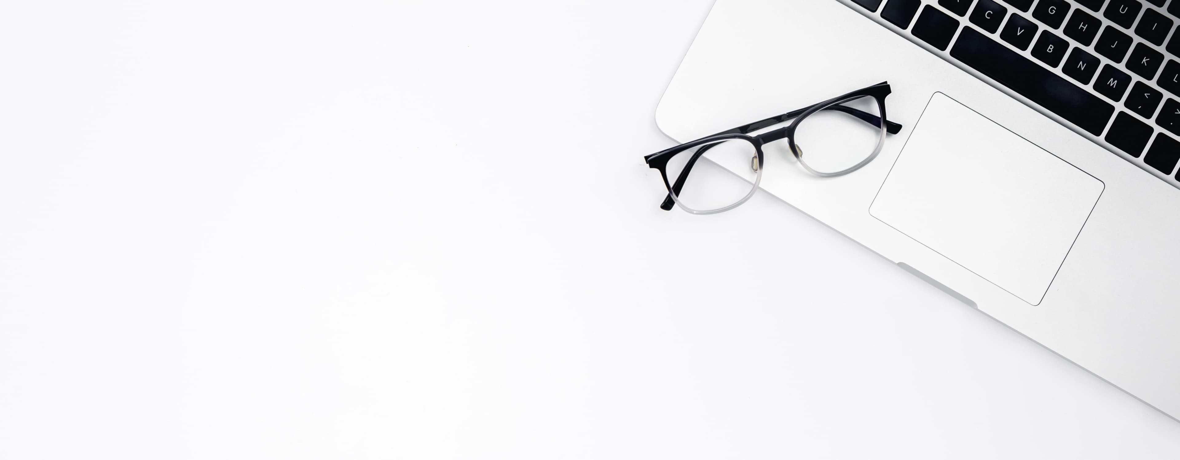 Desk workspace with glasses and laptop